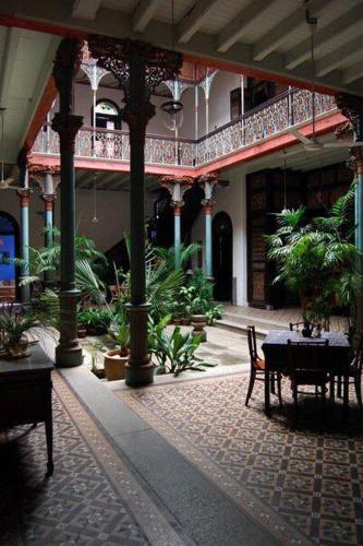 a courtyard with a table and chairs in a building at Cheong Fatt Tze - The Blue Mansion in George Town