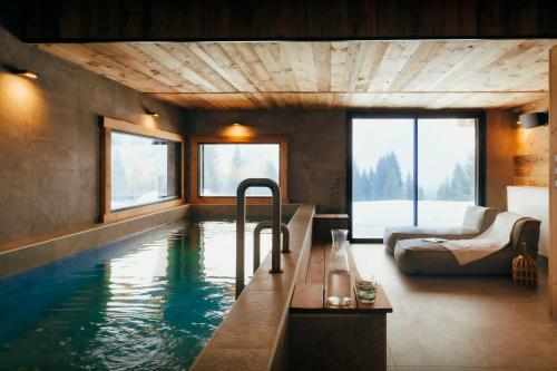 Habitación con piscina, sofá y cama en Chalet 1786 - OVO Network, en Notre-Dame-de-Bellecombe