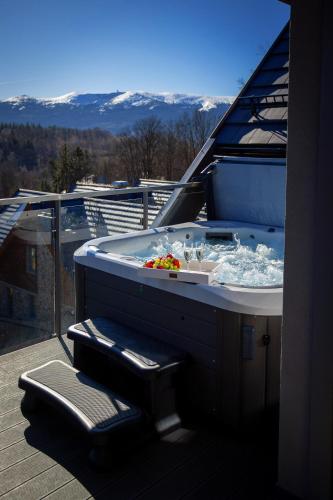 a hot tub on the roof of a house at Kras-Resort Apartament 301 i 303 z widokiem na góry, prywatnym jacuzzi na tarasie i sauną in Szklarska Poręba