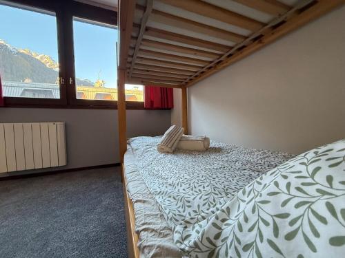 une chambre avec un lit et une grande fenêtre dans l'établissement Joli 2P Mummery centre-ville de Chamonix, à Chamonix-Mont-Blanc