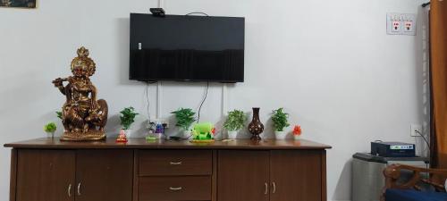 a wooden cabinet with a television on top of it at Whitehouse Villa in Manipala