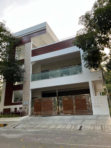 a building with brown doors and a parking lot at Ahika Stays in Bengaluru