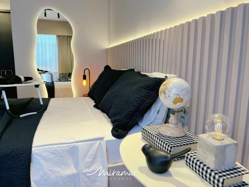 a bedroom with a bed and a table with a globe on it at Beach Haus in Tambaú