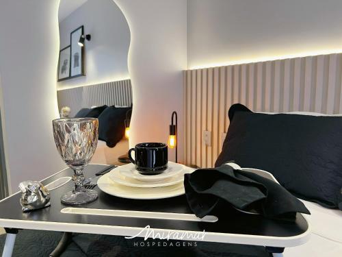 a table with a plate and a cup and a glass at Beach Haus in Tambaú