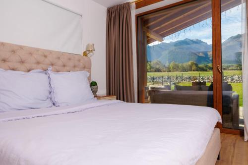 a bedroom with a bed and a large window at Villa Eliyas with Jacuzzi near the Pirin Golf Resort in Razlog