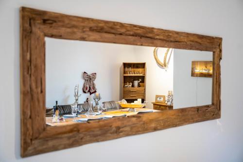 a mirror with a wooden frame hanging on a wall at Ferienhaus Meis Chalet in Scuol