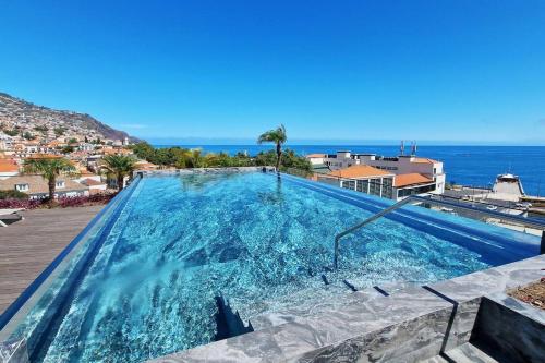 a swimming pool with the ocean in the background at Empire Luxury Suite - Savoy Insular in Funchal
