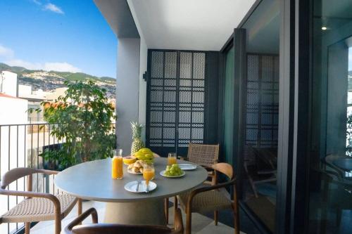 a table with a bowl of fruit on a balcony at Empire Luxury Suite - Savoy Insular in Funchal