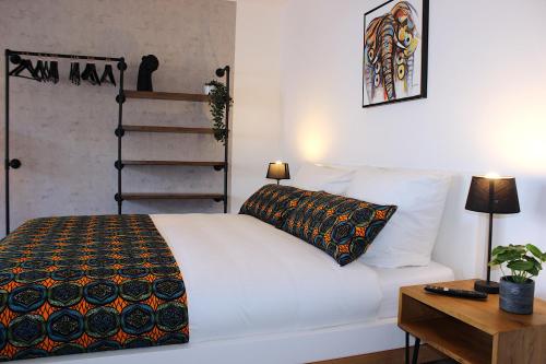 a bedroom with a white bed with a pillow and a table at Mawulo - Stadtwohnung im Zentrum mit Balkon in Neustadt an der Weinstraße