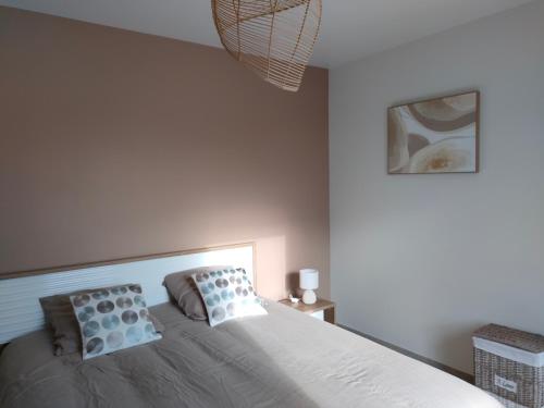 a bedroom with a bed with two pillows on it at Détente à Portbail in Portbail