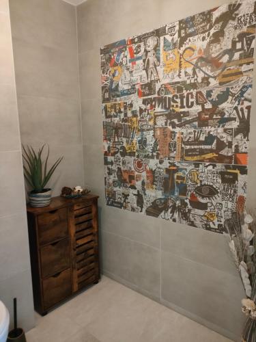 a bathroom with a wall covered in graffiti at Détente à Portbail in Portbail