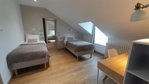 - une chambre mansardée avec 2 lits et un miroir dans l'établissement G2 Chambre familiale domaine Treuillaud piscine, à Villers-les-Ormes
