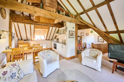 a living room with a table and chairs and a kitchen at Host & Stay - The Clock Tower in Snettisham