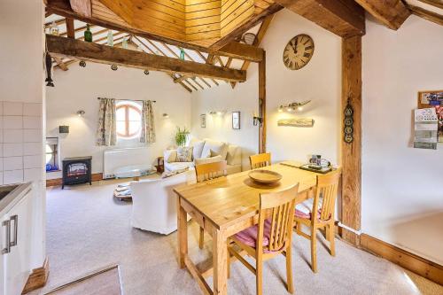 a kitchen and living room with a wooden table and chairs at Host & Stay - The Clock Tower in Snettisham