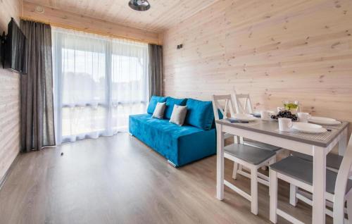 ein Wohnzimmer mit einem blauen Sofa und einem Tisch in der Unterkunft Gorgeous Home In Krynica Morska in Krynica Morska