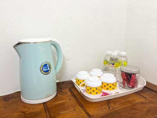 a tea kettle sitting on top of a wooden table at Padang Besar Homestay Firdaus in Padang Besar