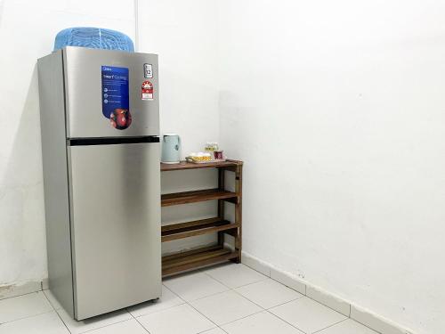 a silver refrigerator in a room with a shelf at Padang Besar Homestay Firdaus in Padang Besar
