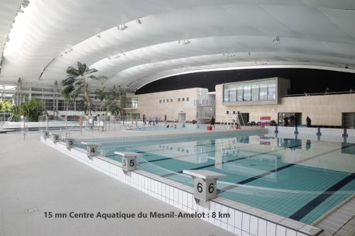 a large swimming pool in a large building at Charmant F2 de Vémars- Parc Astérix - Mer de Sable - Villepinte - Aéroport CDG in Vémars