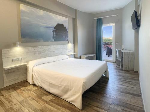 a bedroom with a large white bed and a window at Te Maná Hotel in Torreblanca