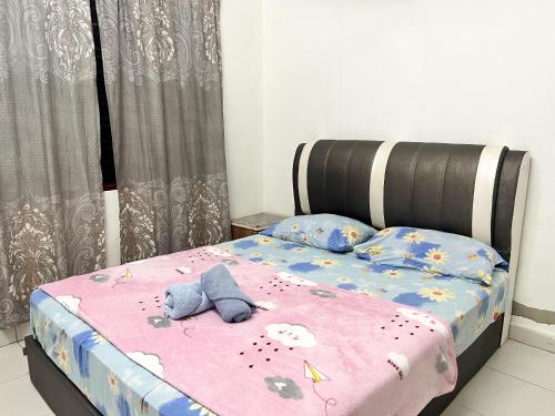 a bed with two stuffed animals on top of it at Padang Besar Homestay Firdaus in Padang Besar