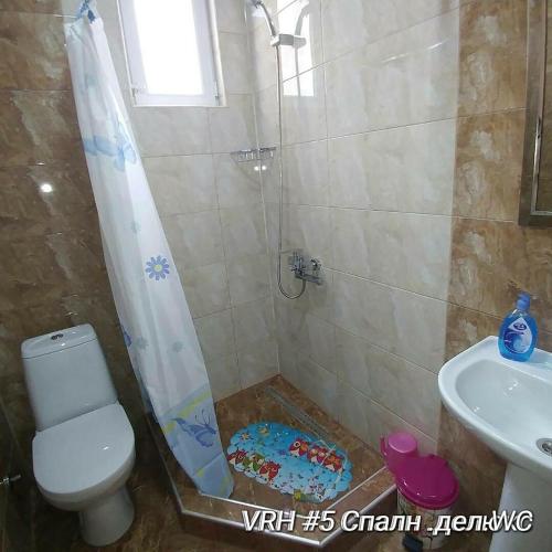 a bathroom with a shower and a toilet and a sink at Villa Royal House in Makhinjauri