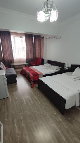 a hotel room with two beds and a window at Villa Royal House in Makhinjauri