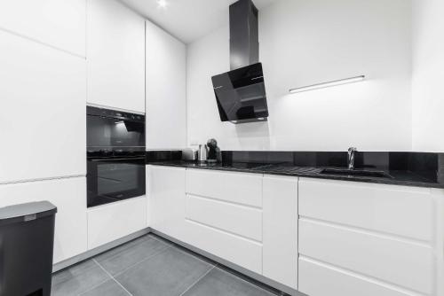 une cuisine blanche avec un évier et une cuisinière dans l'établissement Appartement proche metro et montmartre - paris 18 - 4P, à Paris