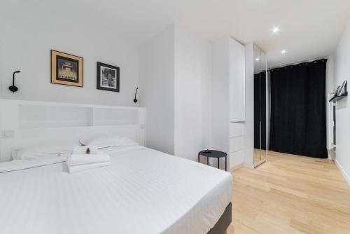 une chambre blanche avec un grand lit et une fenêtre dans l'établissement Appartement proche metro et montmartre - paris 18 - 4P, à Paris
