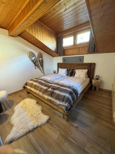 a bedroom with a large bed and a wooden ceiling at Ferienhaus Meis Chalet in Scuol