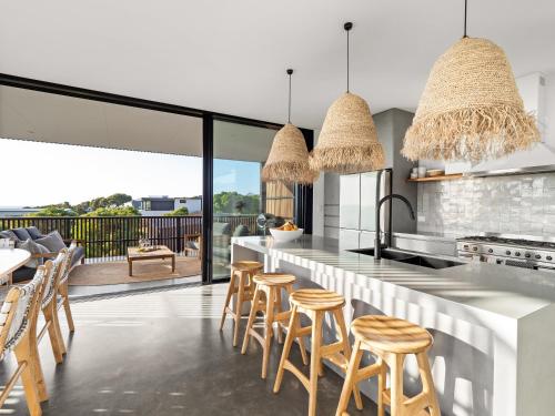 a kitchen with a bar with stools at Lumiere-Stunning Coastal Retreat in Gnarabup