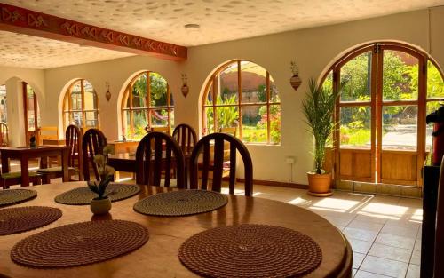 una sala da pranzo con tavolo, sedie e finestre di Casa De paz a Písac