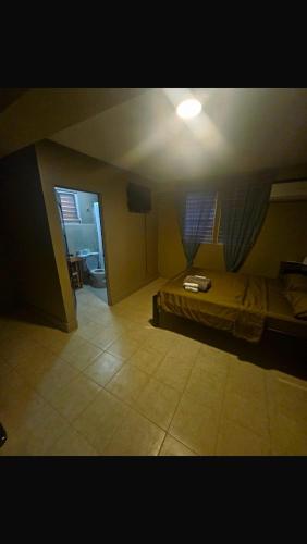 a bedroom with a bed and a room with a hallway at Hotel Martin in Corozal