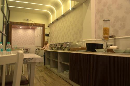 a kitchen with a sink and a person in the mirror at Subhash Hotel in Prayagraj