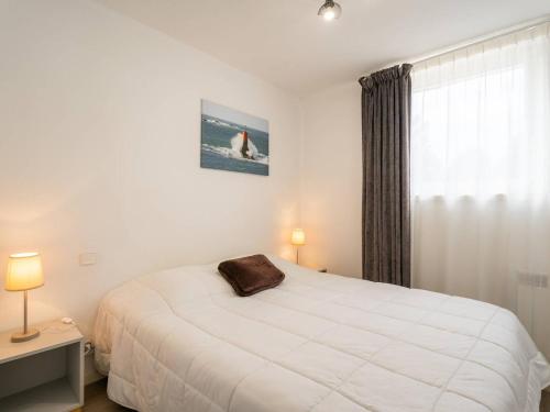 une chambre avec un lit blanc et une fenêtre dans l'établissement Appartement cosy avec parking à La Trinité-sur-Mer - FR-1-477-34, à La Trinité-sur-Mer