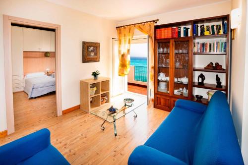 sala de estar con sofá azul y dormitorio en Appartamento Letojanni-Taormina, en Letojanni