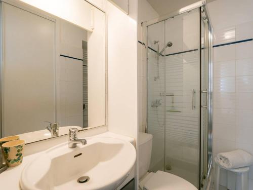 une salle de bain blanche avec un lavabo et une douche dans l'établissement La Trinité-sur-Mer : Bel Appart 3 Pièces, 6 Pers, Wifi, Parking - FR-1-477-173, à La Trinité-sur-Mer