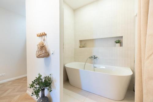 une salle de bain blanche avec une baignoire et un lavabo dans l'établissement L'Harmonieux Beau T3 centre ville, à Montpellier