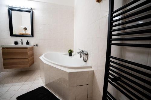 a white bathroom with a tub and a sink at Chateau Děčín in Děčín