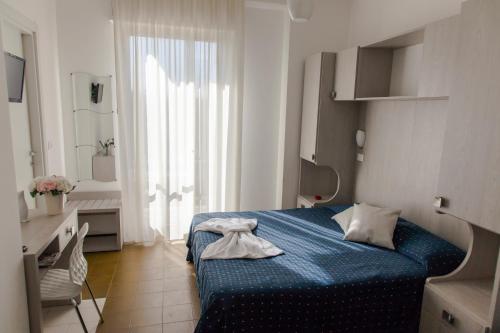 Habitación de hotel con cama azul y baño. en Hotel Concorde, en Bellaria-Igea Marina