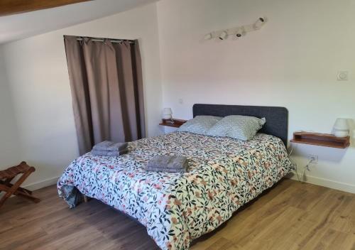- une chambre avec un lit doté d'une couette et d'oreillers dans l'établissement La maison du vieux bourg, à Perrier