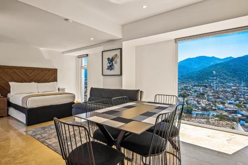 a bedroom with a table and chairs and a bed at Harbor 171 TN 2110 in Puerto Vallarta