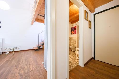 a room with a hallway with wooden floors and a door at Via Fiorenza Apartment in Livorno