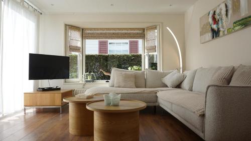 a living room with a couch and a tv at Park Welgelegen, bungalow 28 in Cadzand