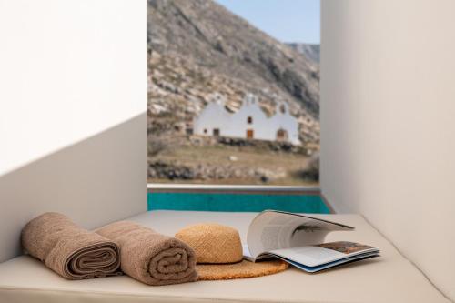 a bathroom counter with towels and a book on it at Depalyma Suites in Emporio Santorini