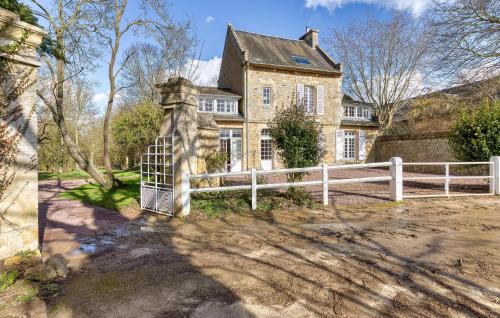une vieille maison avec une clôture devant elle dans l'établissement Pet Friendly Home In Baron-Sur-Odon, à Baron-sur-Odon