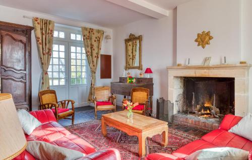 un salon avec des meubles rouges et une cheminée dans l'établissement Pet Friendly Home In Baron-Sur-Odon, à Baron-sur-Odon