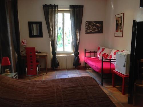 a bedroom with a bed and a table and a window at La Mandarinette in La Seyne-sur-Mer