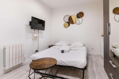 une chambre avec un lit, une table et une télévision dans l'établissement Studio fonctionnel hopital bichat - paris 18 - 2P, à Paris