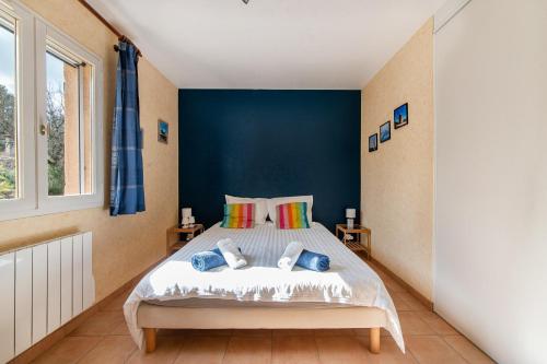 une chambre avec un lit avec un mur bleu dans l'établissement Montgit - Piscine grand jardin parking, à Montmeyan