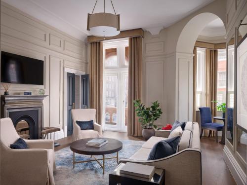 a living room with a couch and a fireplace at Kimpton Fitzroy London by IHG in London
